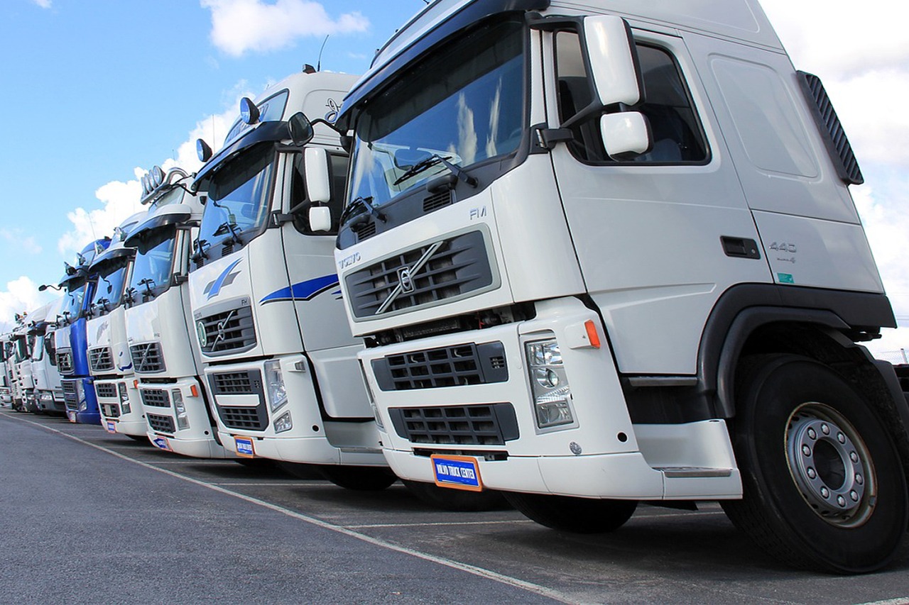 A line of commercial fleet trucks parked at a depot